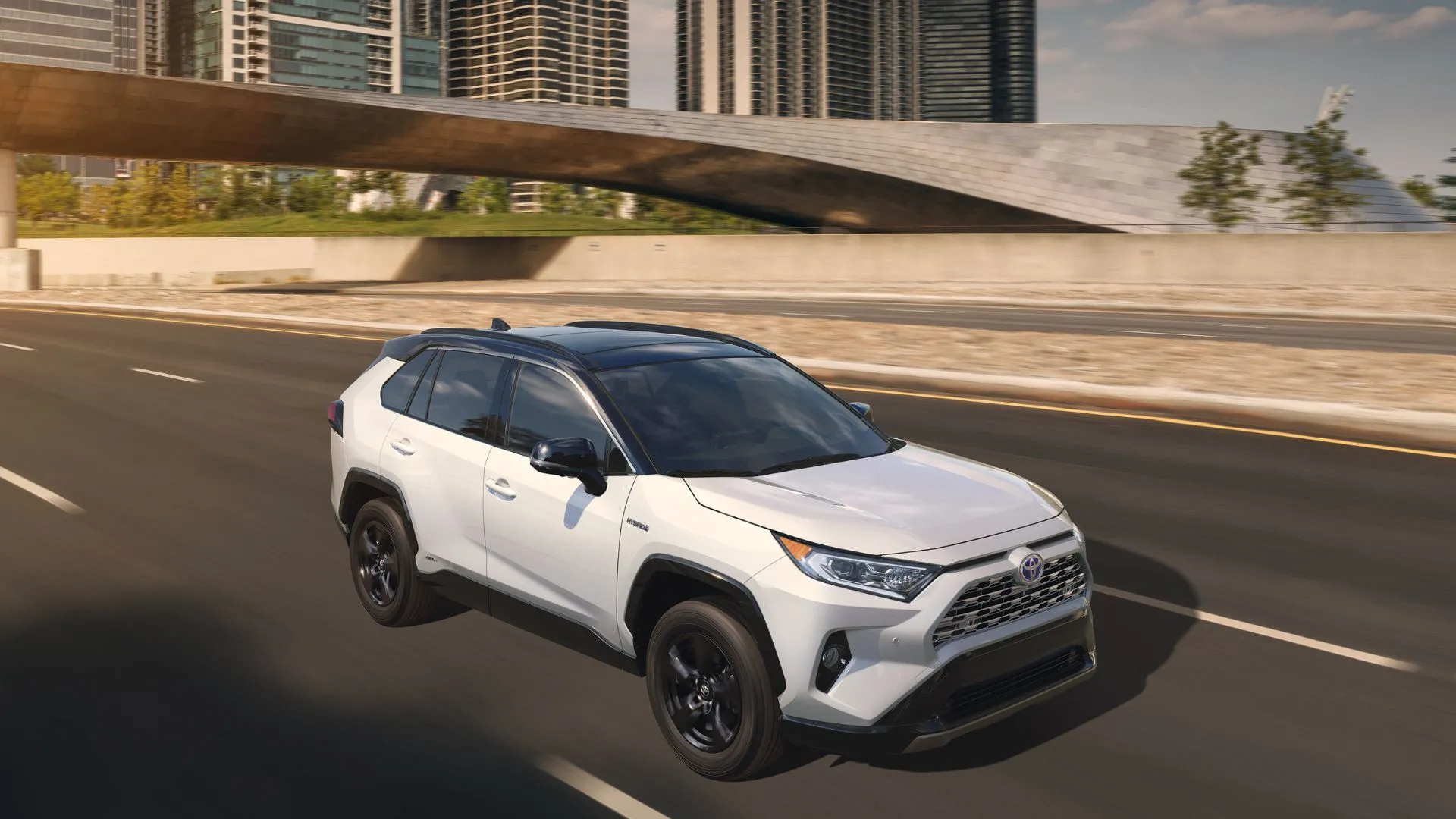Toyota RAV4 2019 màu trắng năng động di chuyển trên đường cao tốc đô thị, thể hiện sự linh hoạt và tiện ích của xe.