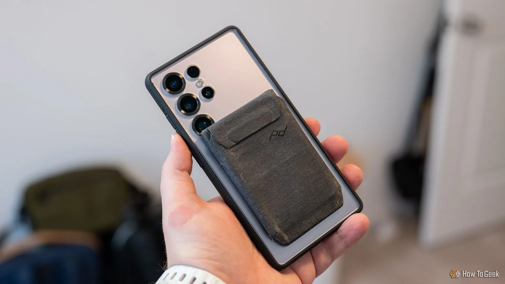 Ví Peak Design Mobile Wallet gắn vào ốp lưng dbrand Ghost 2.0 trên Samsung Galaxy S25 Ultra, che một phần camera