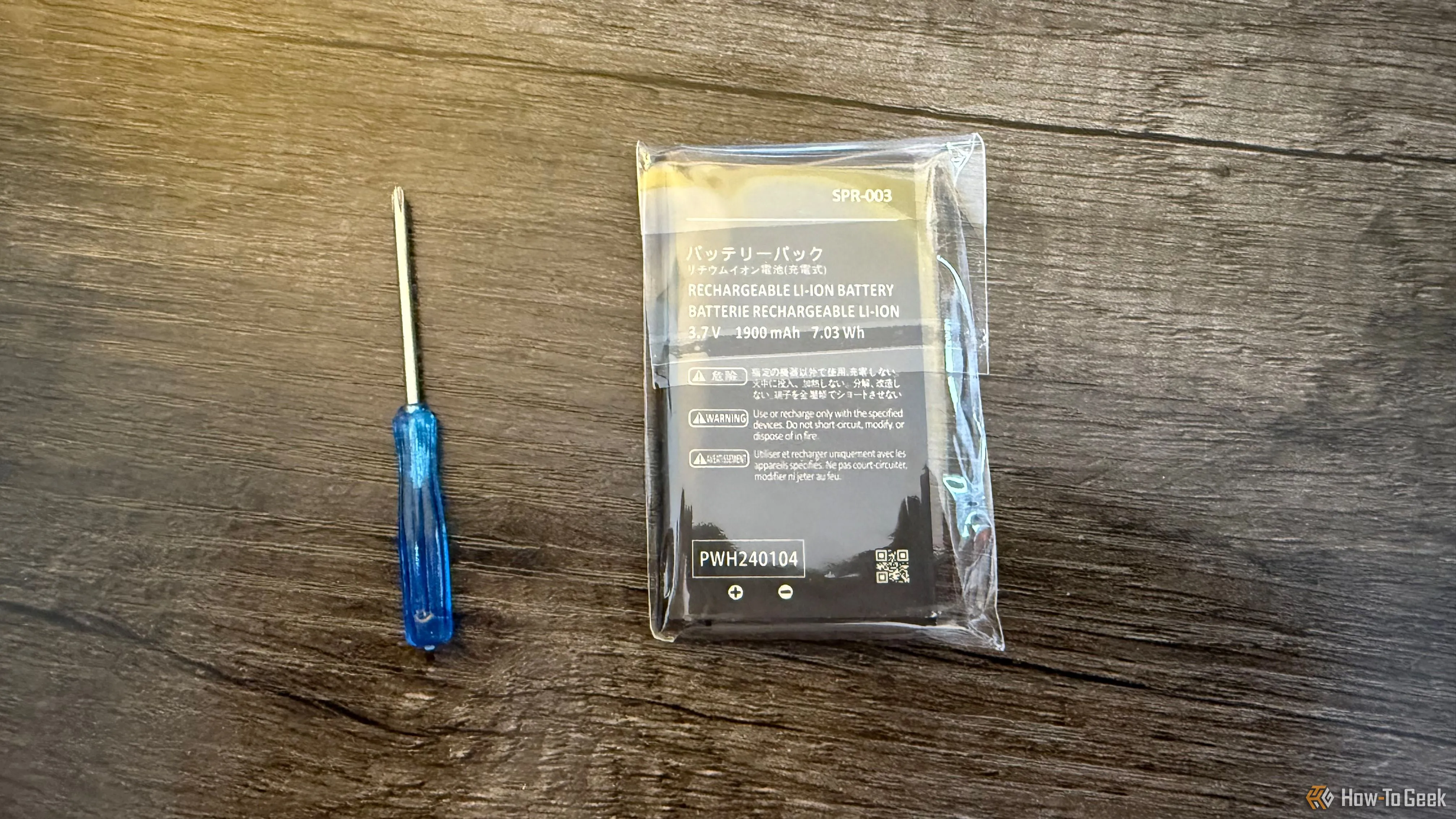 Viên pin thay thế cho Nintendo 3DS SPR-003 được bảo quản trong vỏ nhựa và một tua vít nhỏ, minh họa cho việc bảo quản pin đúng cách.