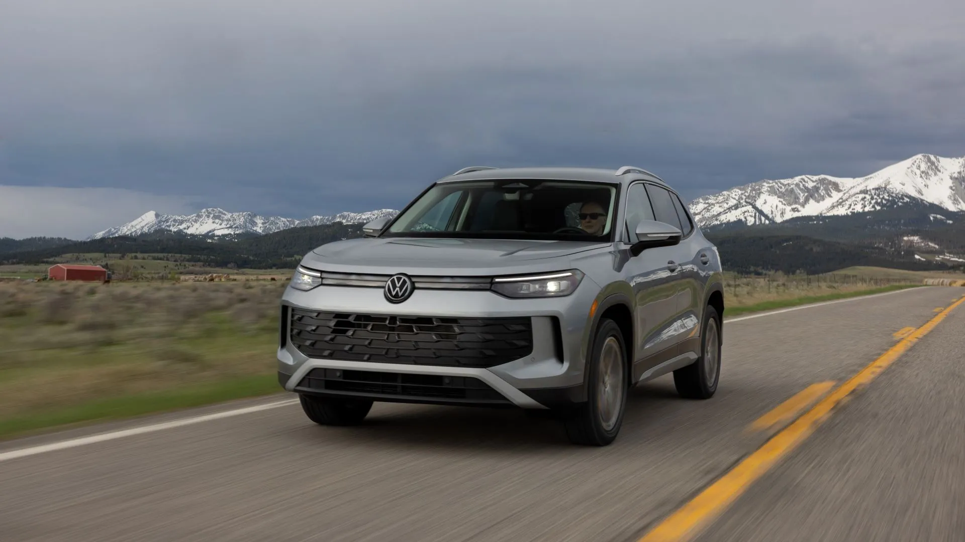Volkswagen Tiguan 2025 màu vàng đồng đang di chuyển trên đường.