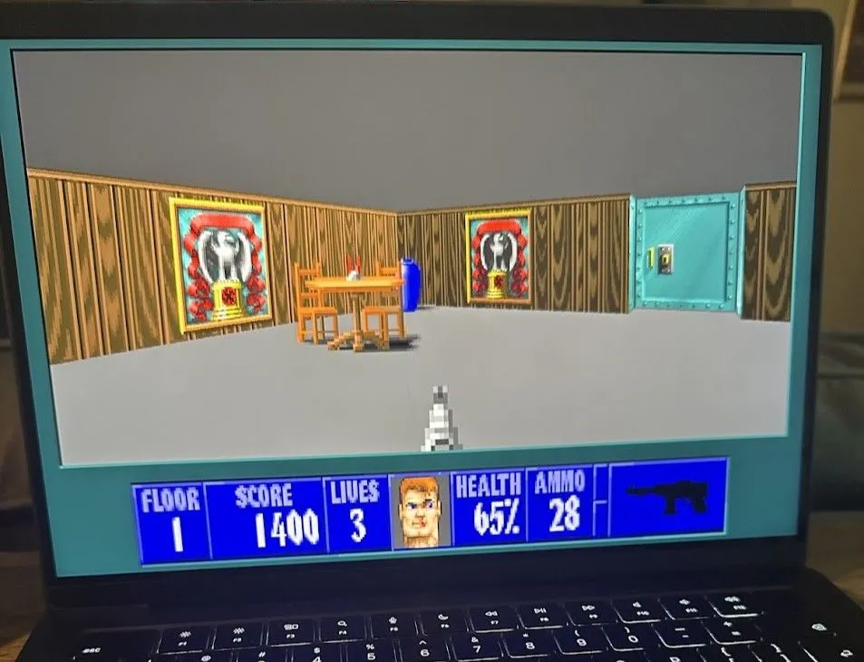 Wolf3D đang chạy trên MacBook Pro, hiển thị giao diện game bắn súng góc nhìn thứ nhất với đồ họa pixel cổ điển, nhân vật đang bắn quân địch trong một hành lang.