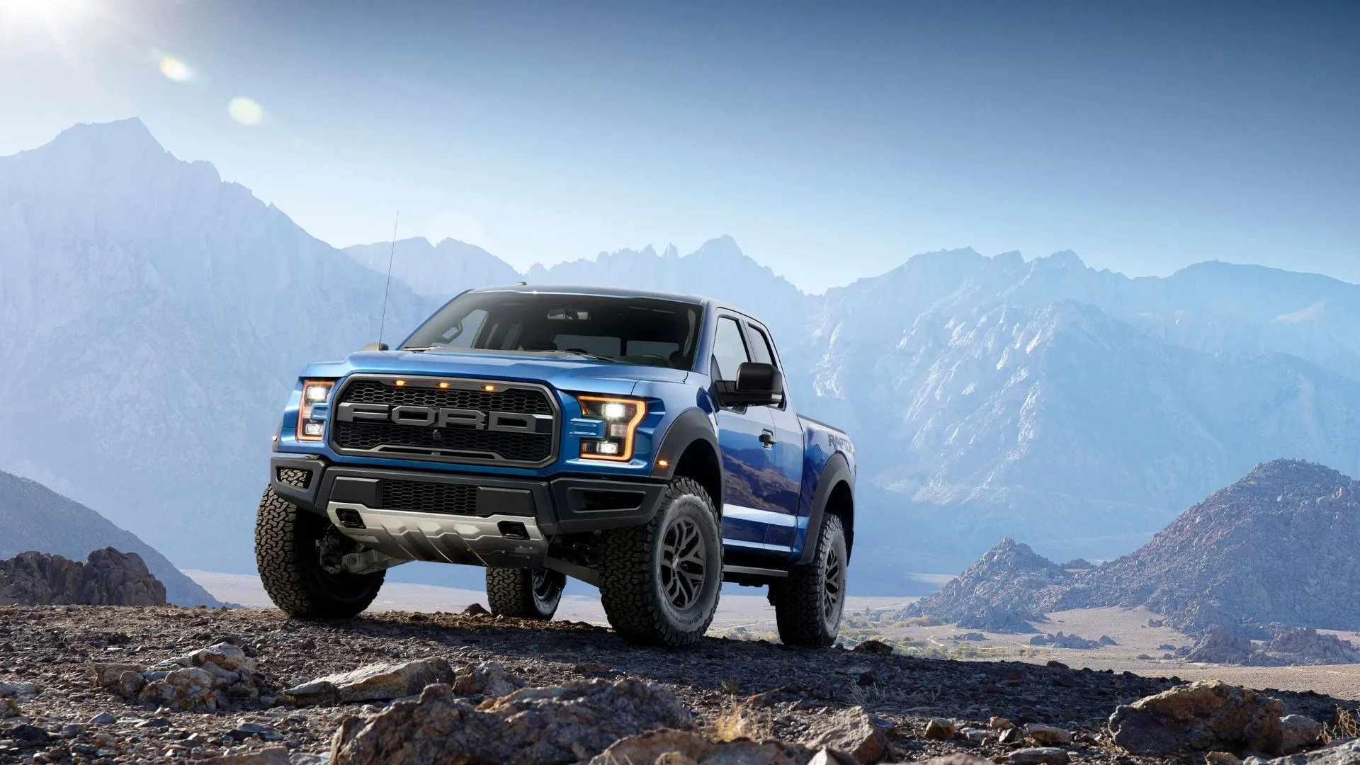 Xe Ford F-150 Raptor 2017 màu xanh dương chạy off-road trên địa hình đồi núi, minh họa các mẫu xe F-150 được trang bị hộp số khác nhau.