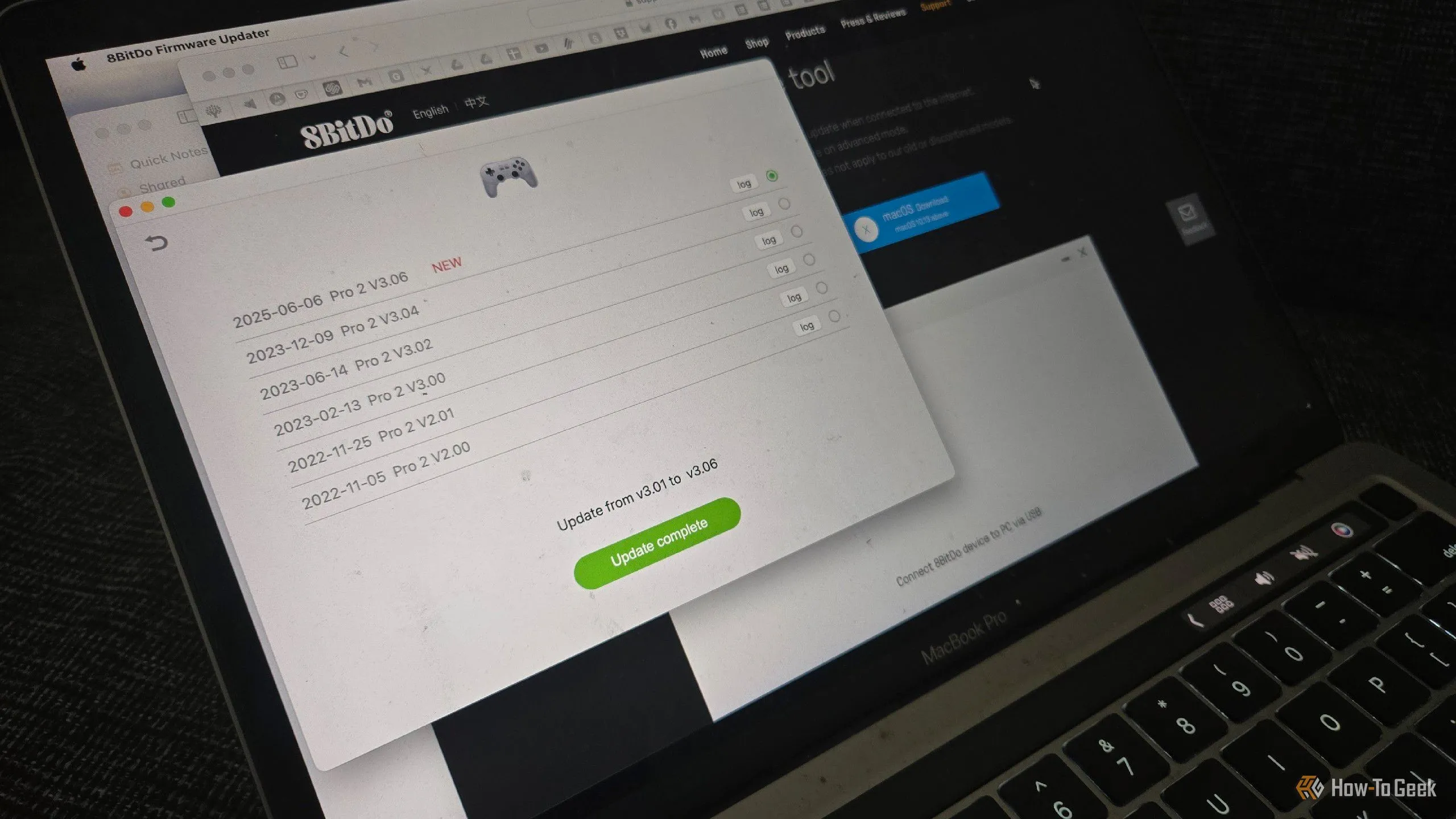 Tay cầm chơi game 8BitDo Pro 2 đang được kết nối với MacBook để cập nhật firmware, cho thấy sự phụ thuộc vào máy tính truyền thống.