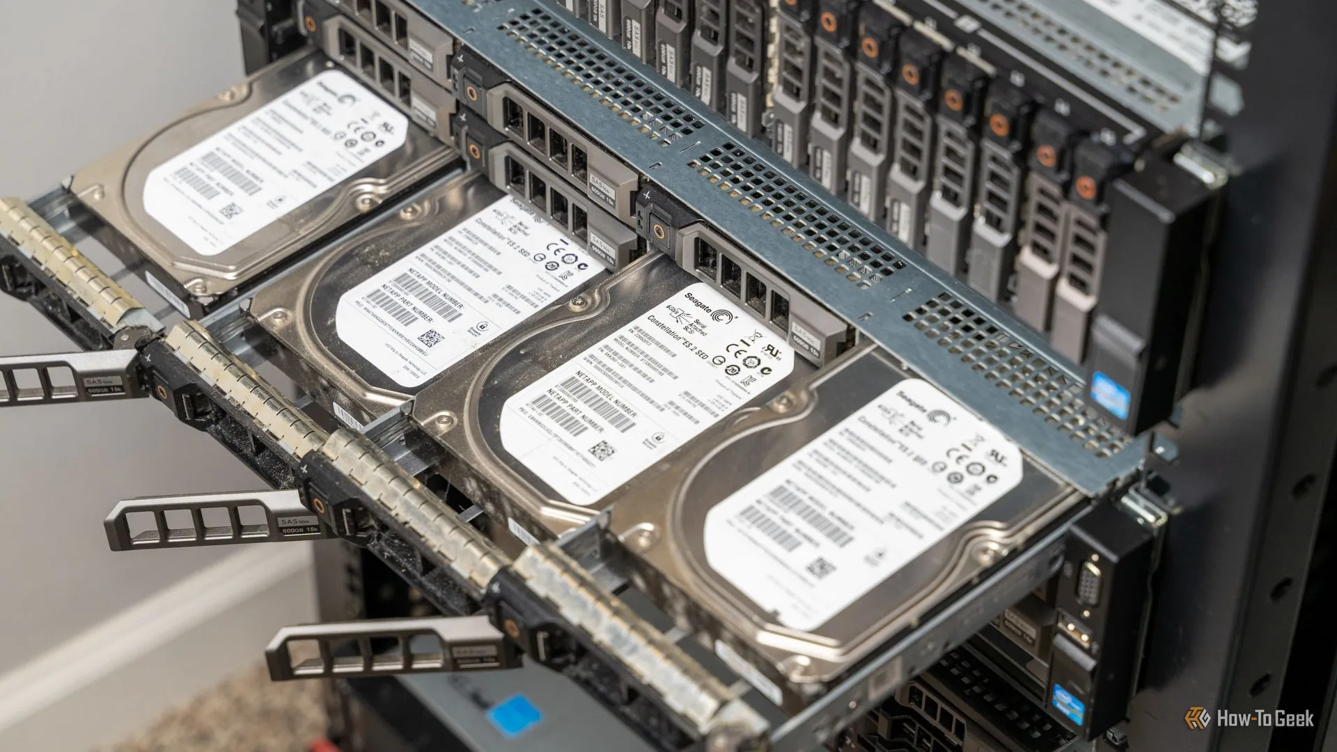 Bốn ổ cứng HDD nhô ra từ máy chủ rack-mount, biểu tượng cho hệ thống lưu trữ server