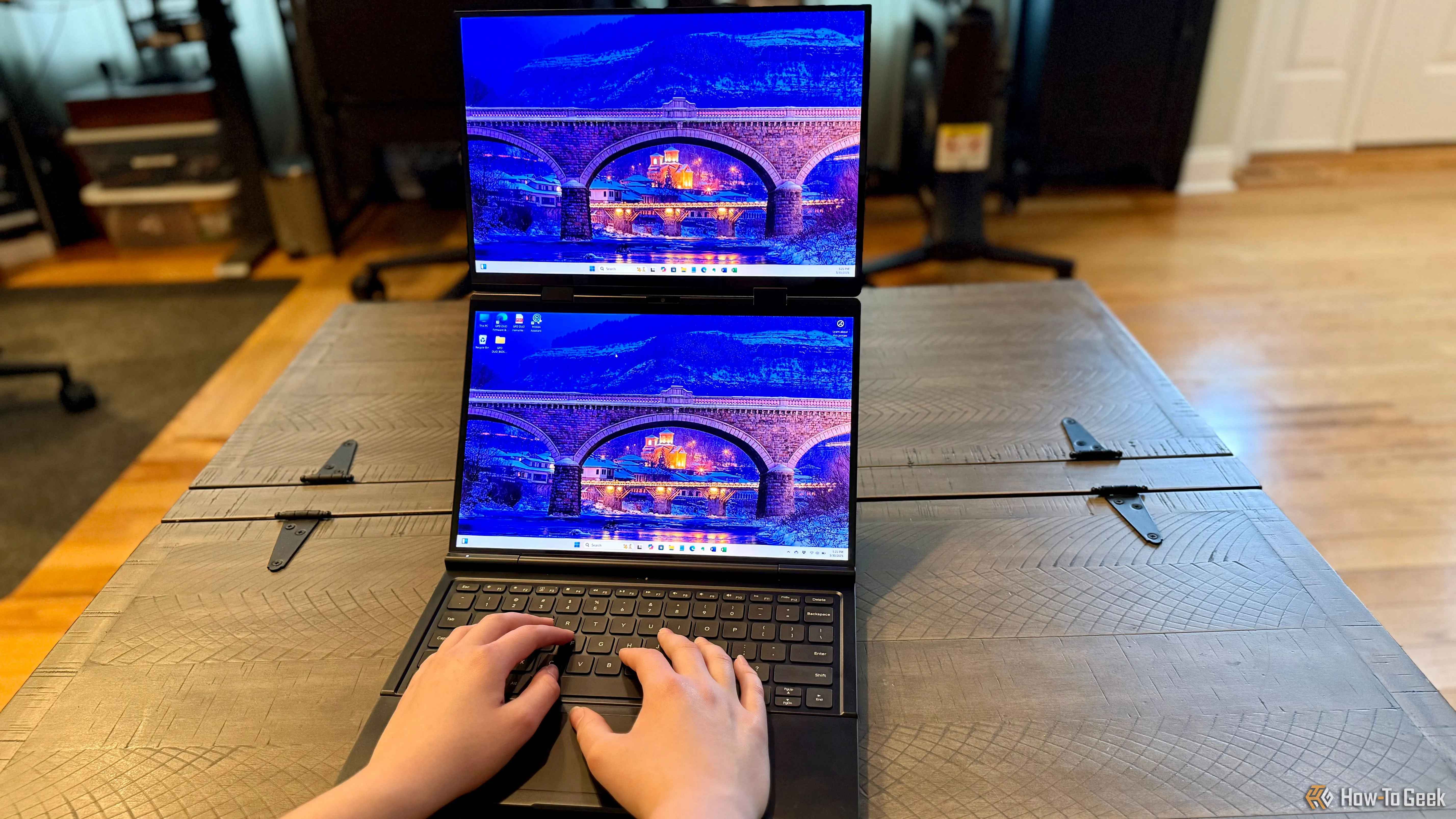 GPD Duo được sử dụng trên mặt bàn với hai màn hình mở ra, làm nổi bật khả năng đa nhiệm và các cổng kết nối