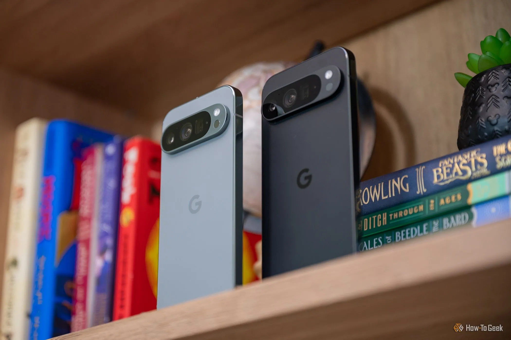 Hai mẫu điện thoại Google Pixel 9 Pro và Pixel 9 Pro XL đứng cạnh nhau trên kệ, làm nổi bật sự khác biệt về kích thước và thiết kế.