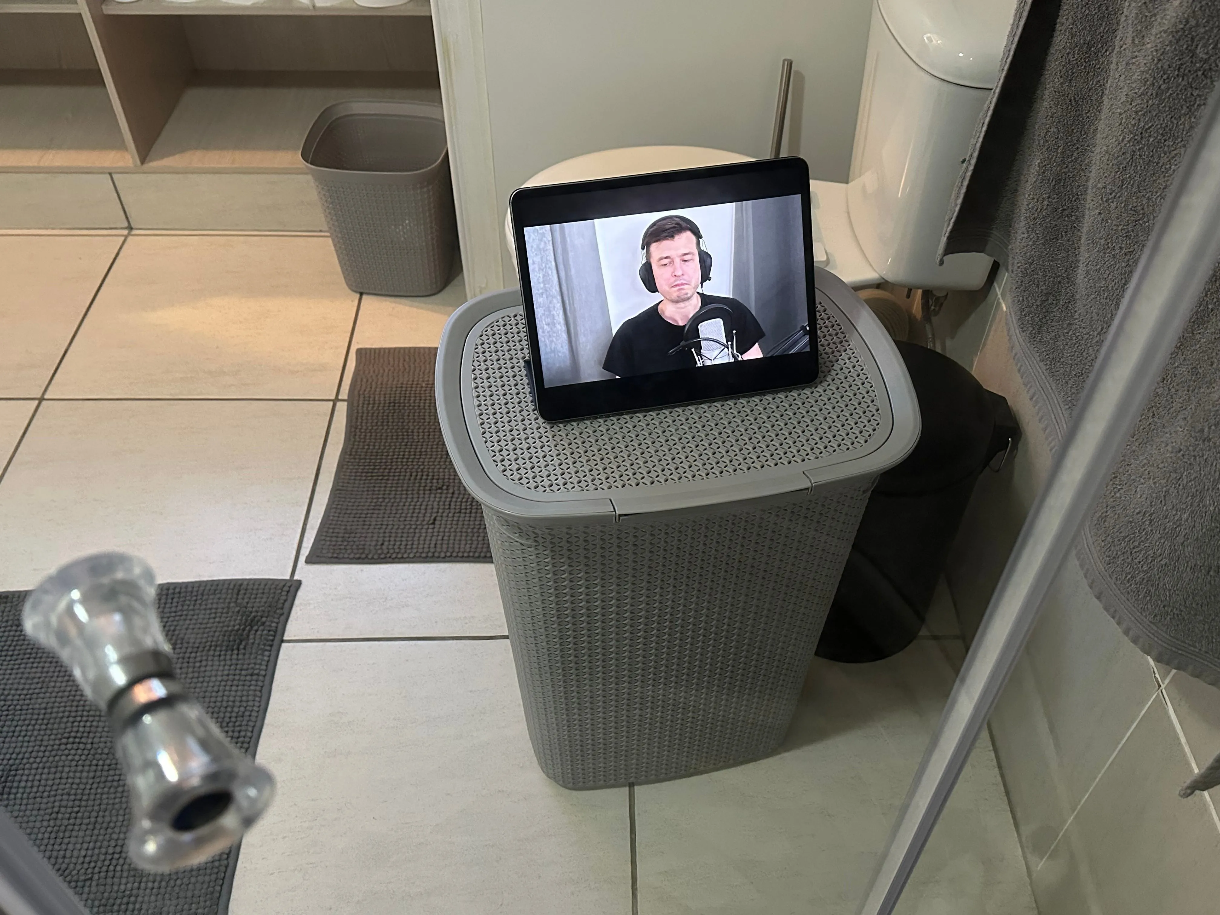 iPad hiển thị video YouTube qua cửa phòng tắm, thể hiện tính di động và khả năng giải trí linh hoạt của thiết bị