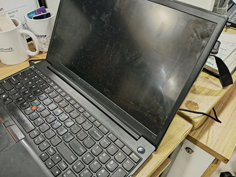 Màn hình laptop bị bẩn với nhiều vết vân tay và vết bẩn.