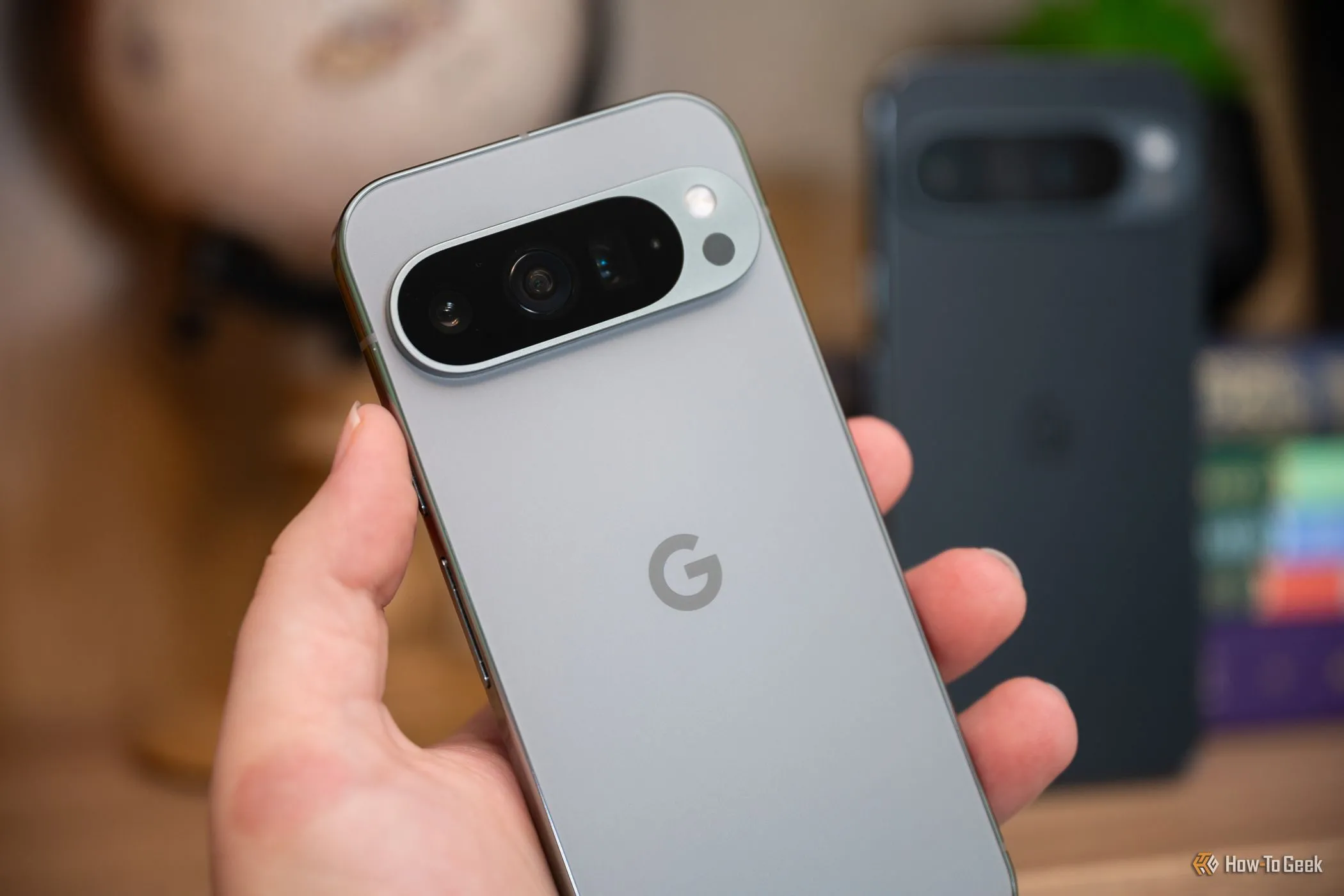 Một người đang cầm điện thoại Google Pixel 9 Pro XL, làm nổi bật cụm camera sau ngang và thiết kế tổng thể của thiết bị.