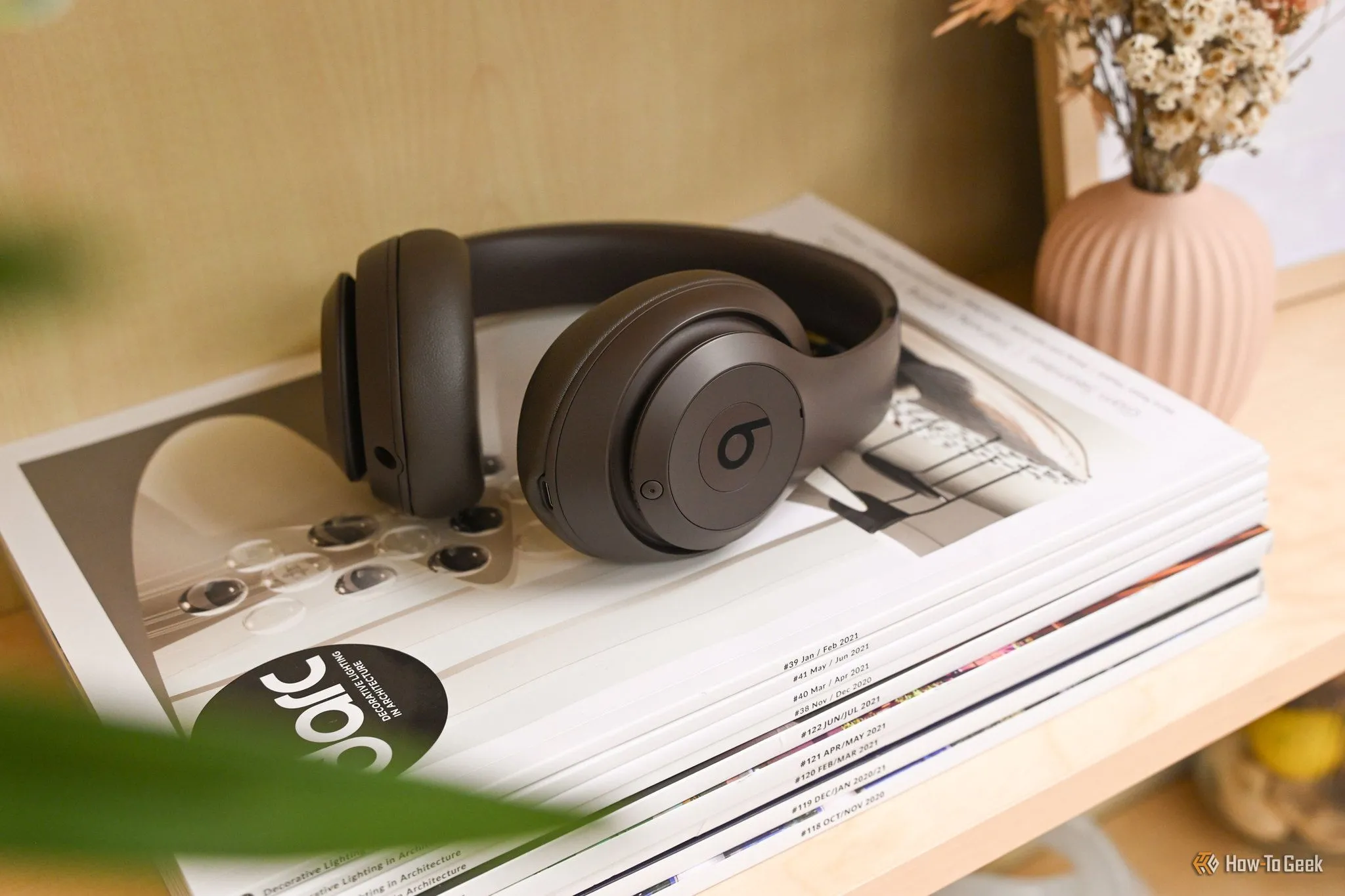 Tai nghe Beats Studio Pro màu nâu trầm đặt trên tạp chí công nghệ